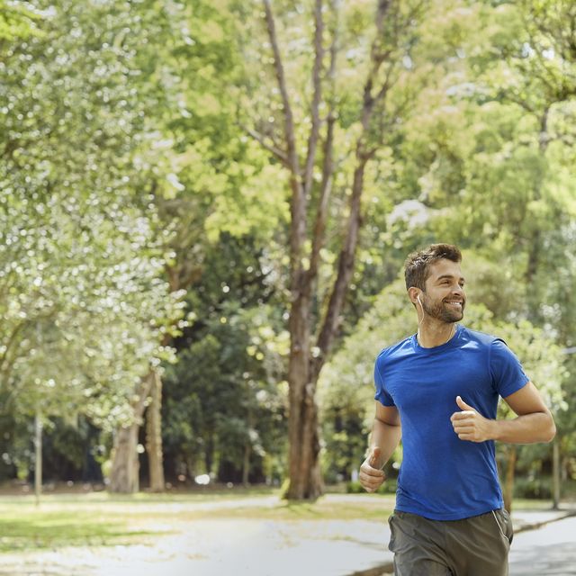 male with in ear headphones jogging in park