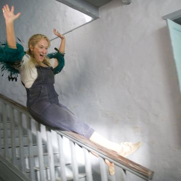 a person in a dress jumping on a staircase