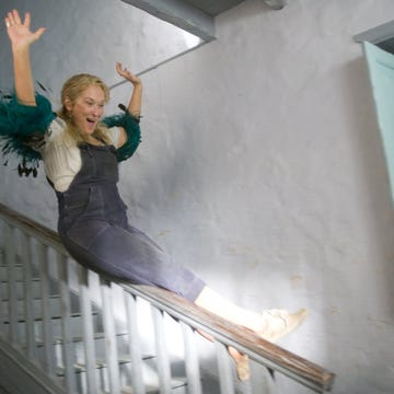 a person in a dress jumping on a staircase