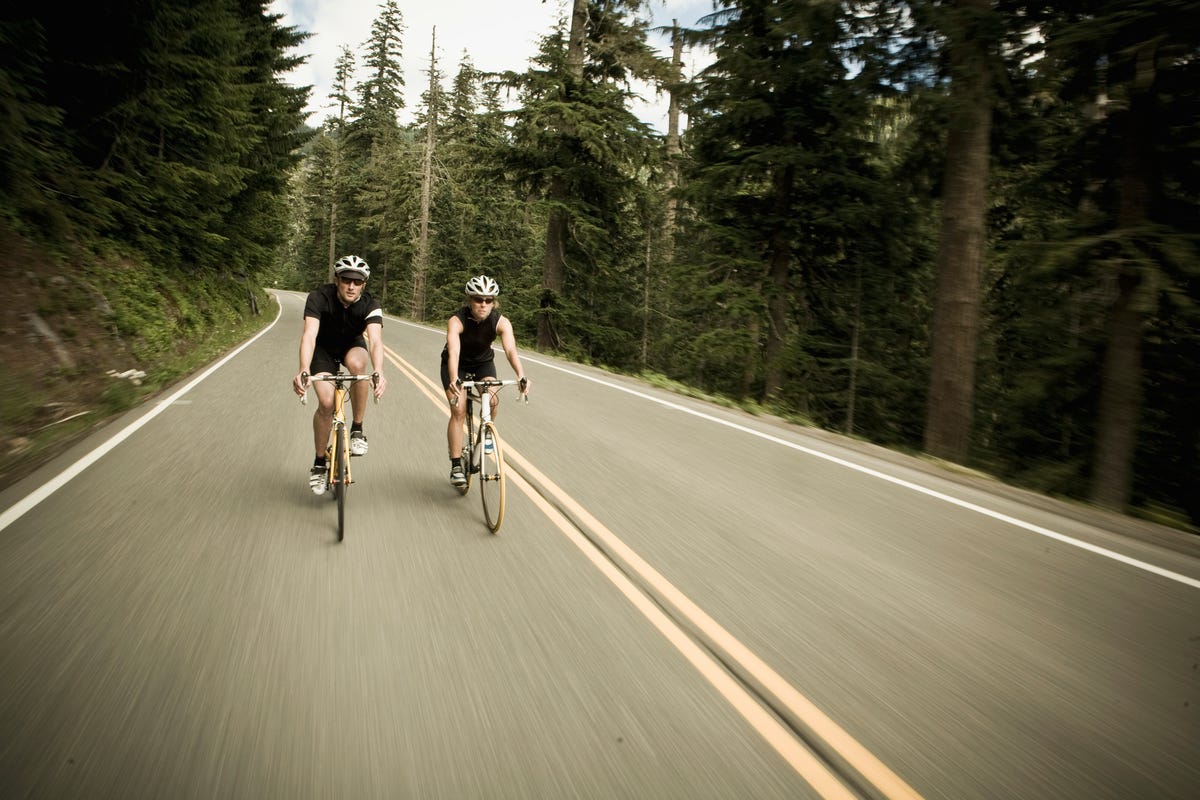 man and woman bicycling though the forest royalty free image