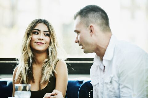 Man and woman in discussion while sharing drinks in bar