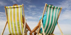 Man and woman on beach in deckchairs