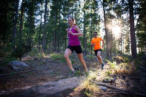 Man and woman running in the forest early morning