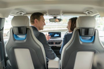 man and woman sitting in electric car, manchester, uk