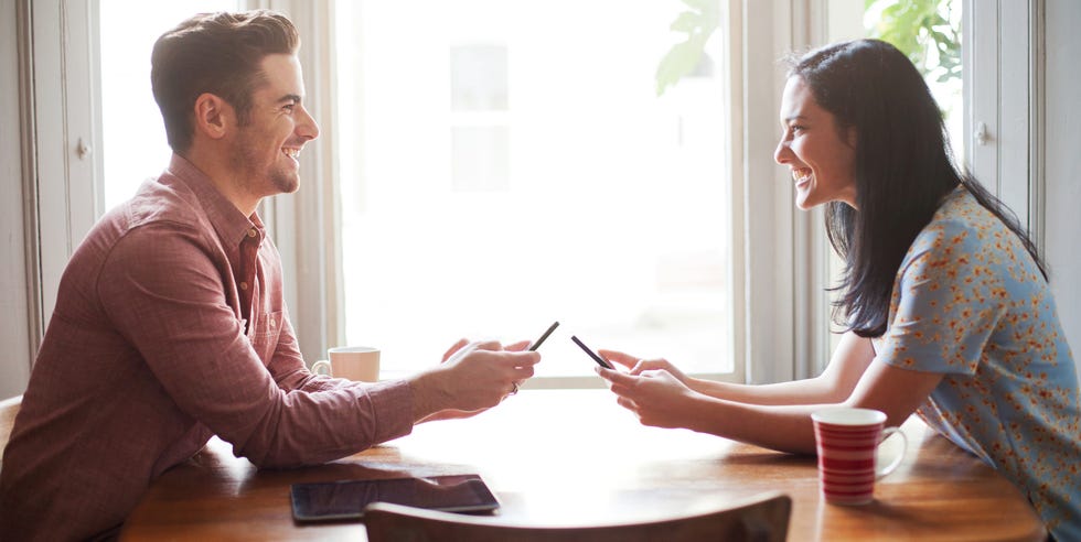 Hombre y mujer usando teléfonos inteligentes en la mesa. hombre y mujer usando teléfonos inteligentes en la mesa