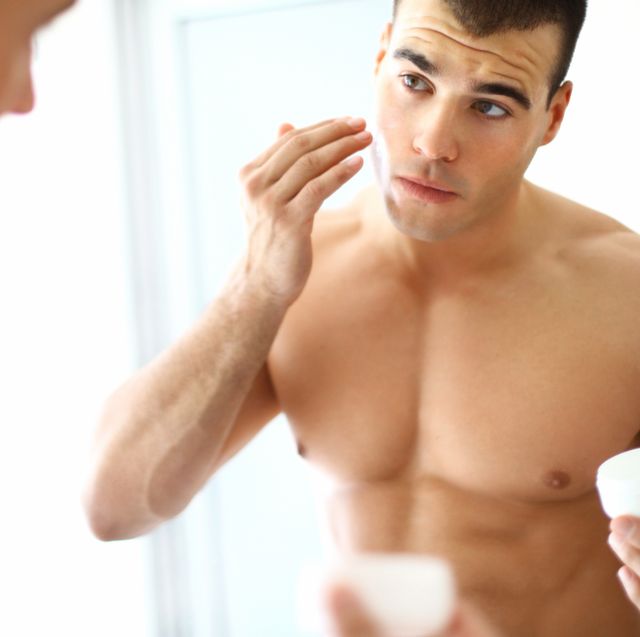 man applying moisturizer