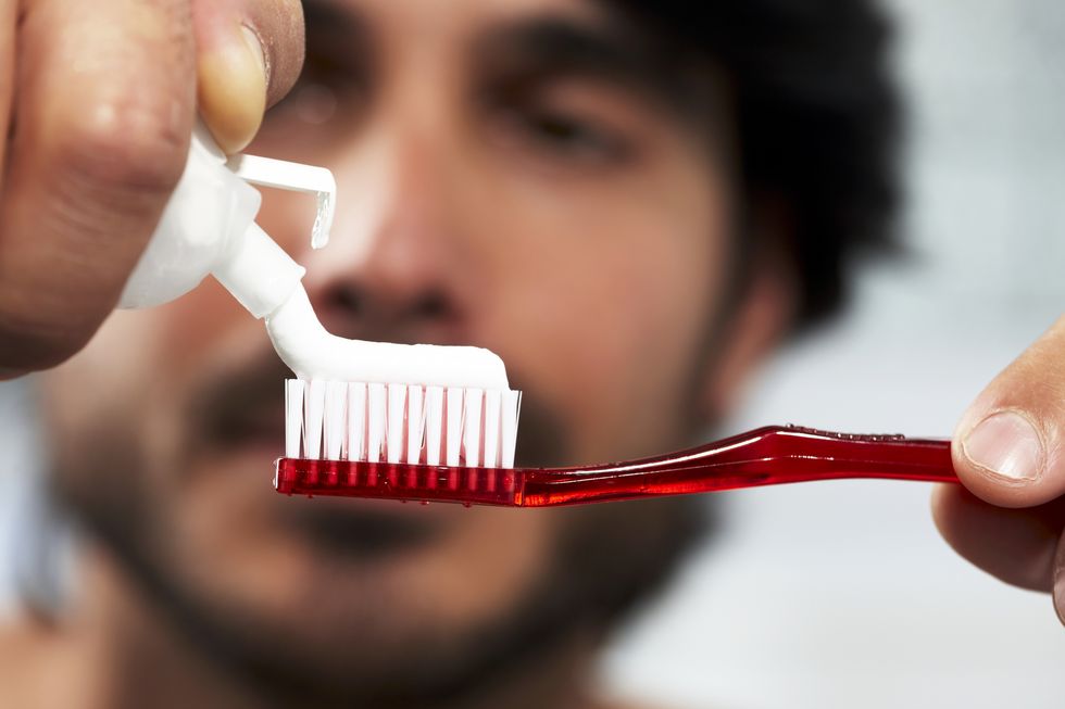 man applying toothpaste to brush