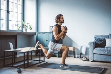 young men at home exercising he is watching online sports class