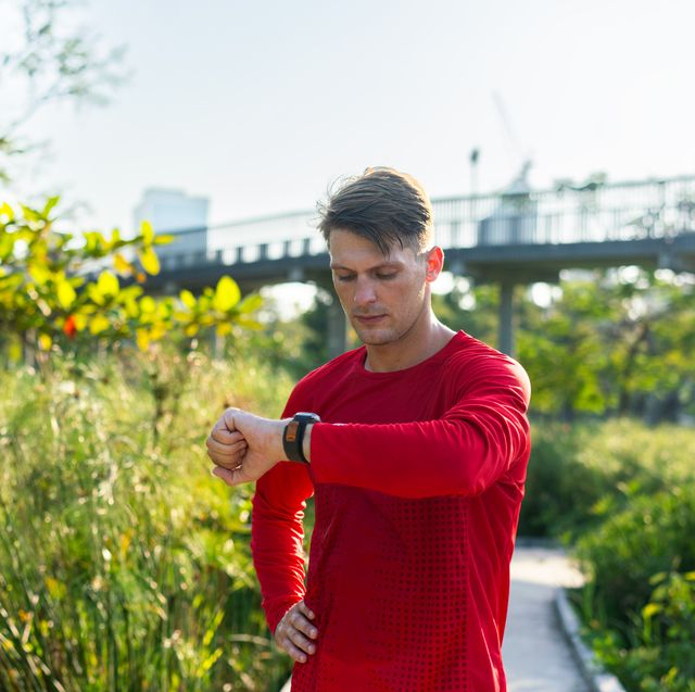 man checking fitness tracker in park