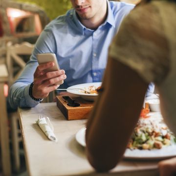 man checking messages while having dinner in a restaurant