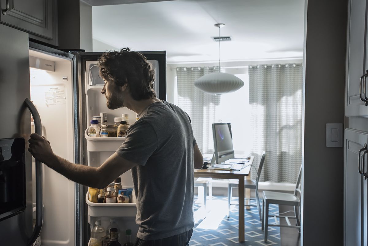 man checks refrigerator