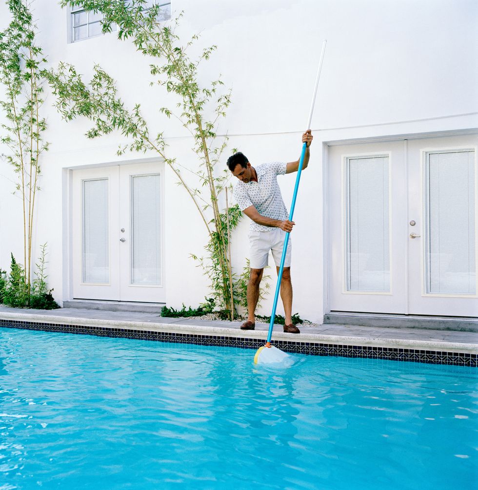 man cleaning out swimming pool