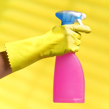 gloved hand holding a cleaner spray bottle