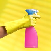 gloved hand holding a cleaner spray bottle