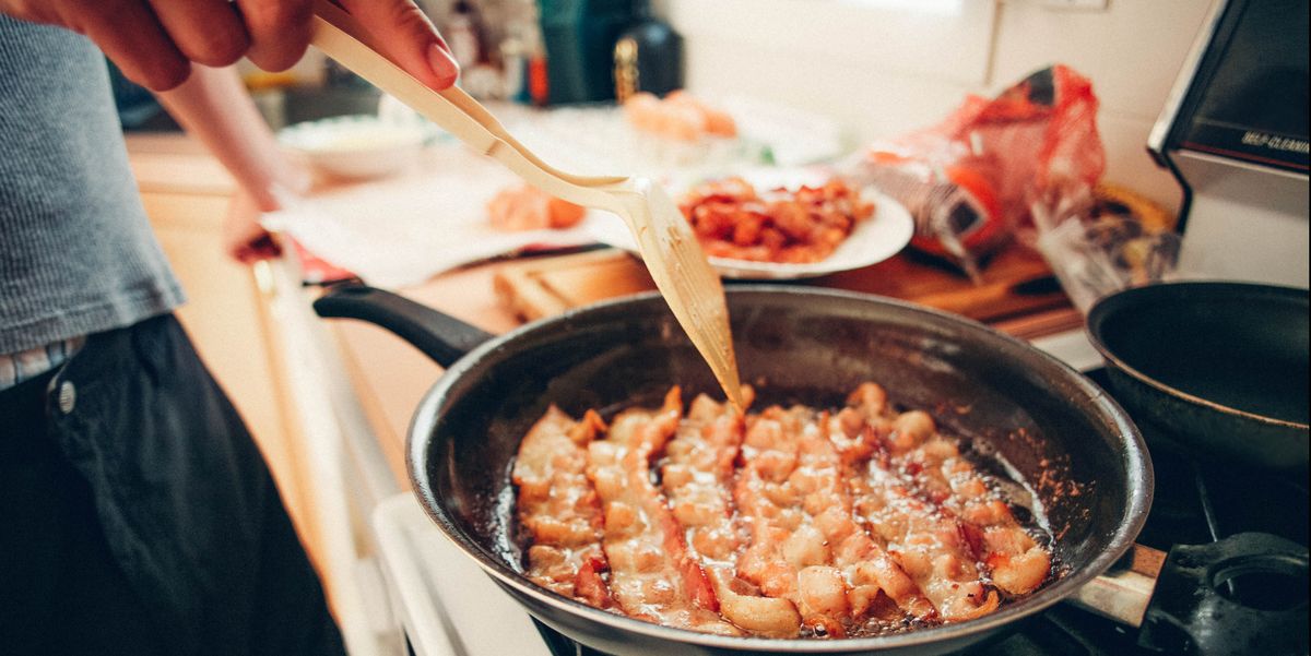 man cooking bacon in frying pan on stove, greasy food, unhealthy diet, breakfast