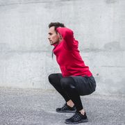 man crouching and exercising outdoors