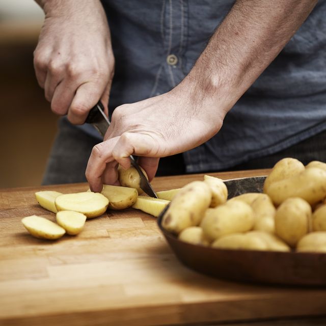 man cutting potatoes in kitchen