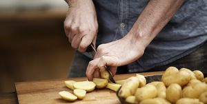 man cutting potatoes in kitchen