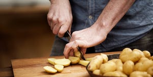 man cutting potatoes in kitchen