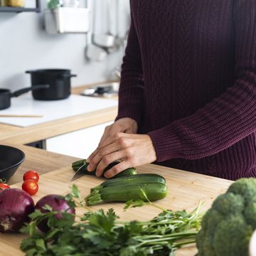 man cutting vegetables on kitchen counter at home
