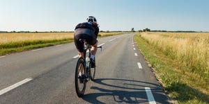 man cycling on country road
