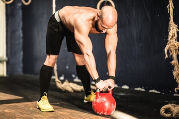 man doing cross fitness exercise with kettlebell