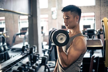 man doing exercise with dumbbell in gym