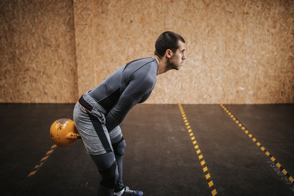 Man doing exercise with kettle bell in gym