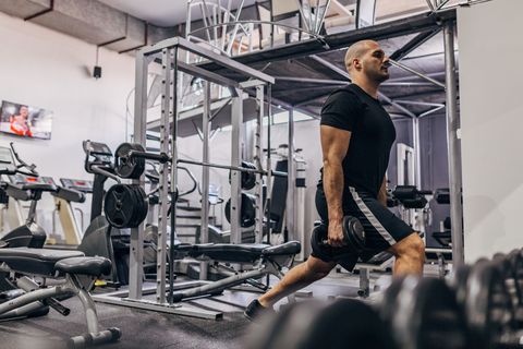 Man doing lunges exercise with dumbbells