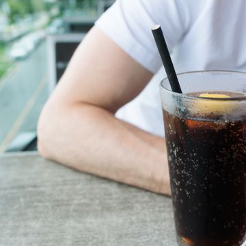 man drinks beverage with paper straw at restaurant