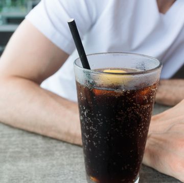 man drinks beverage with paper straw at restaurant