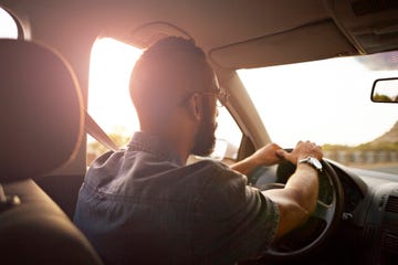 man driving car in the sunset