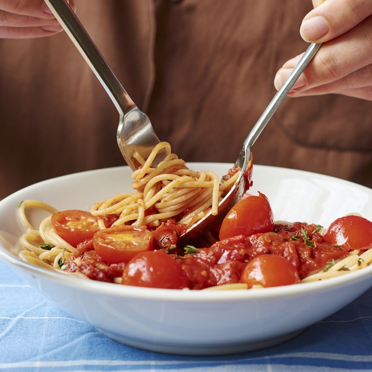 Man eating spaghetti with tomato sauce, close-up