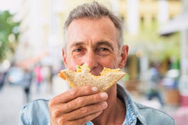 man enjoying a sandwich outdoors