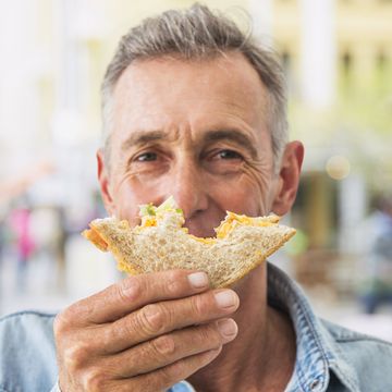 man enjoying a sandwich outdoors.