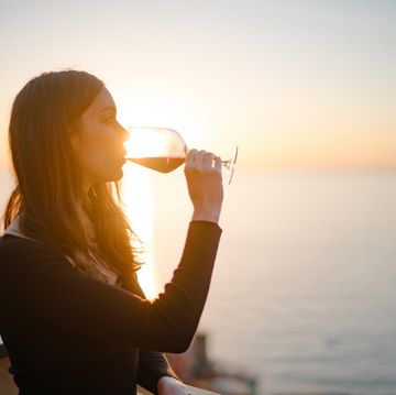 man enjoys red wine on terrace above old town and sea