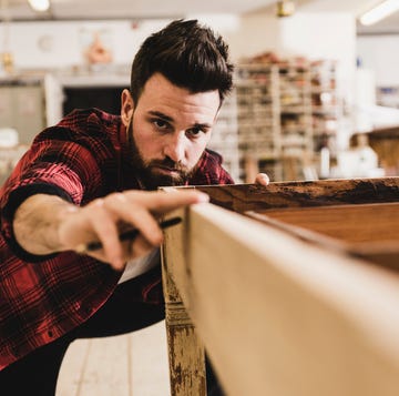 man examining wood in workshop