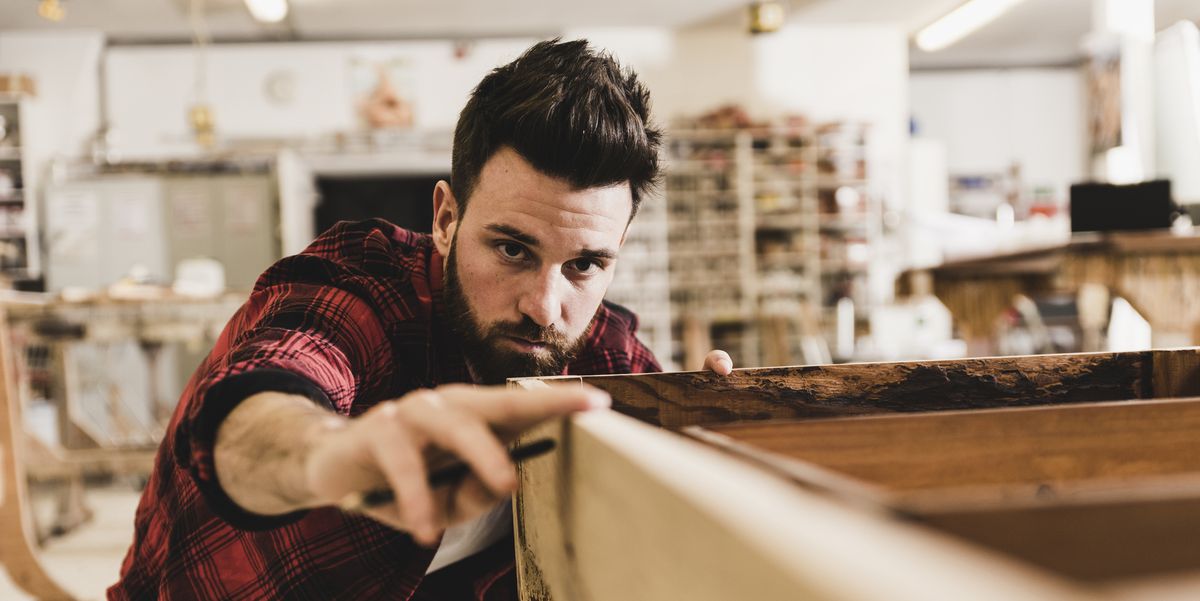 man examining wood in workshop