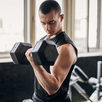 man exercising with dumbbell in gym