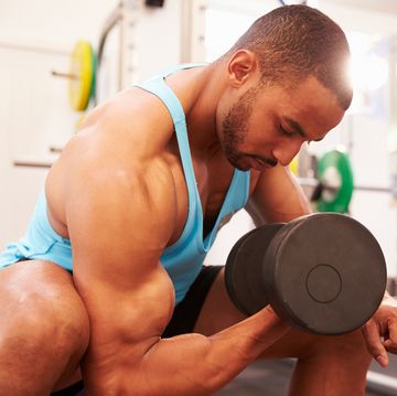 man exercising with dumbbells at a gym, horizontal shot