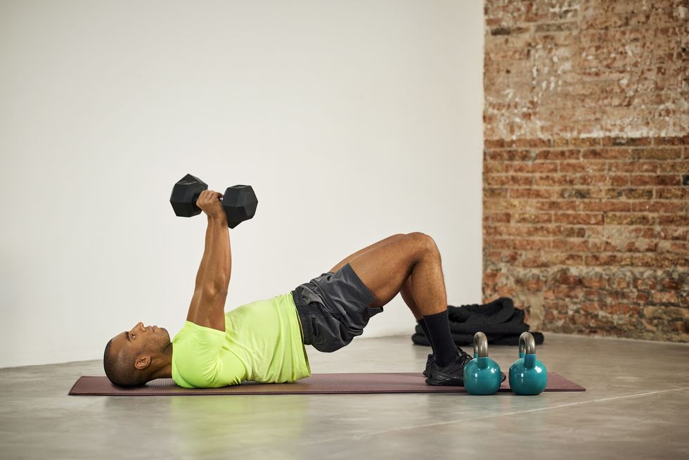 man exercising with dumbbells at home