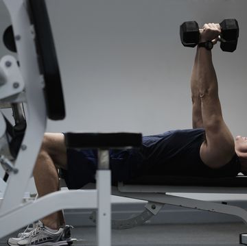 man exercising with dumbbells on weight bench
