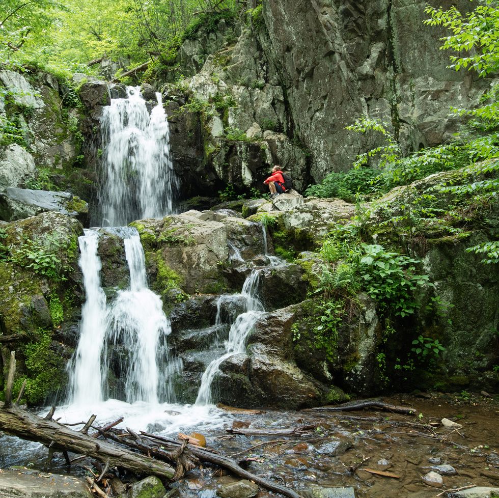 man exploring doyles river falls, shenandoah national park, virginia, usa