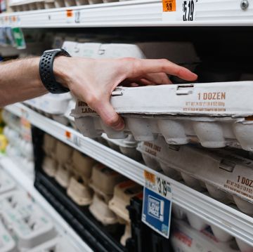 man grabs carton of eggs at supermarket