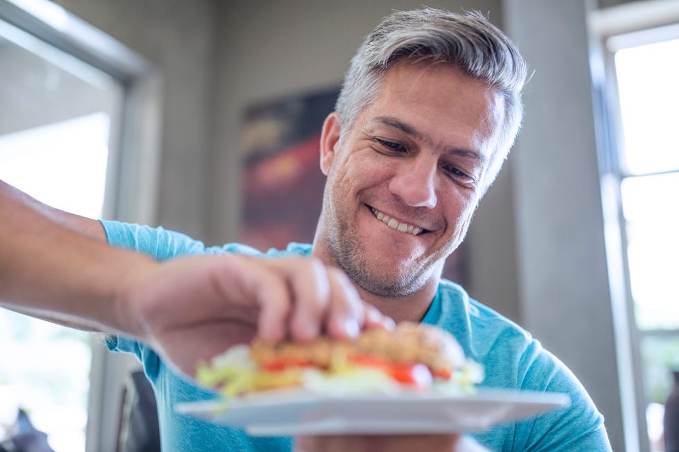 man having a sandwich from plate