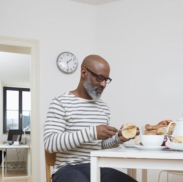 man having late breakfast at his home office