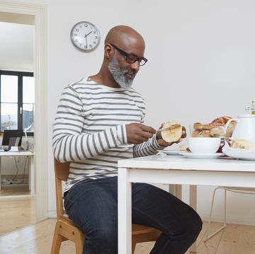 man having late breakfast at his home office