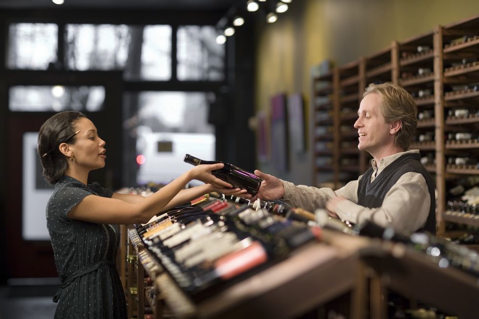 man helping customer select a bottle of wine