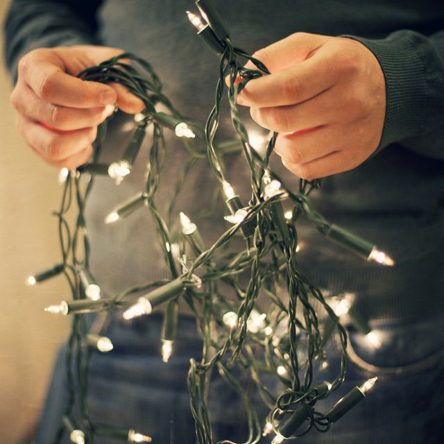 how to fix christmas lights, man holding fairy lights