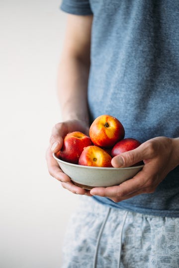 man holding fresh peaches summer healthy food concept